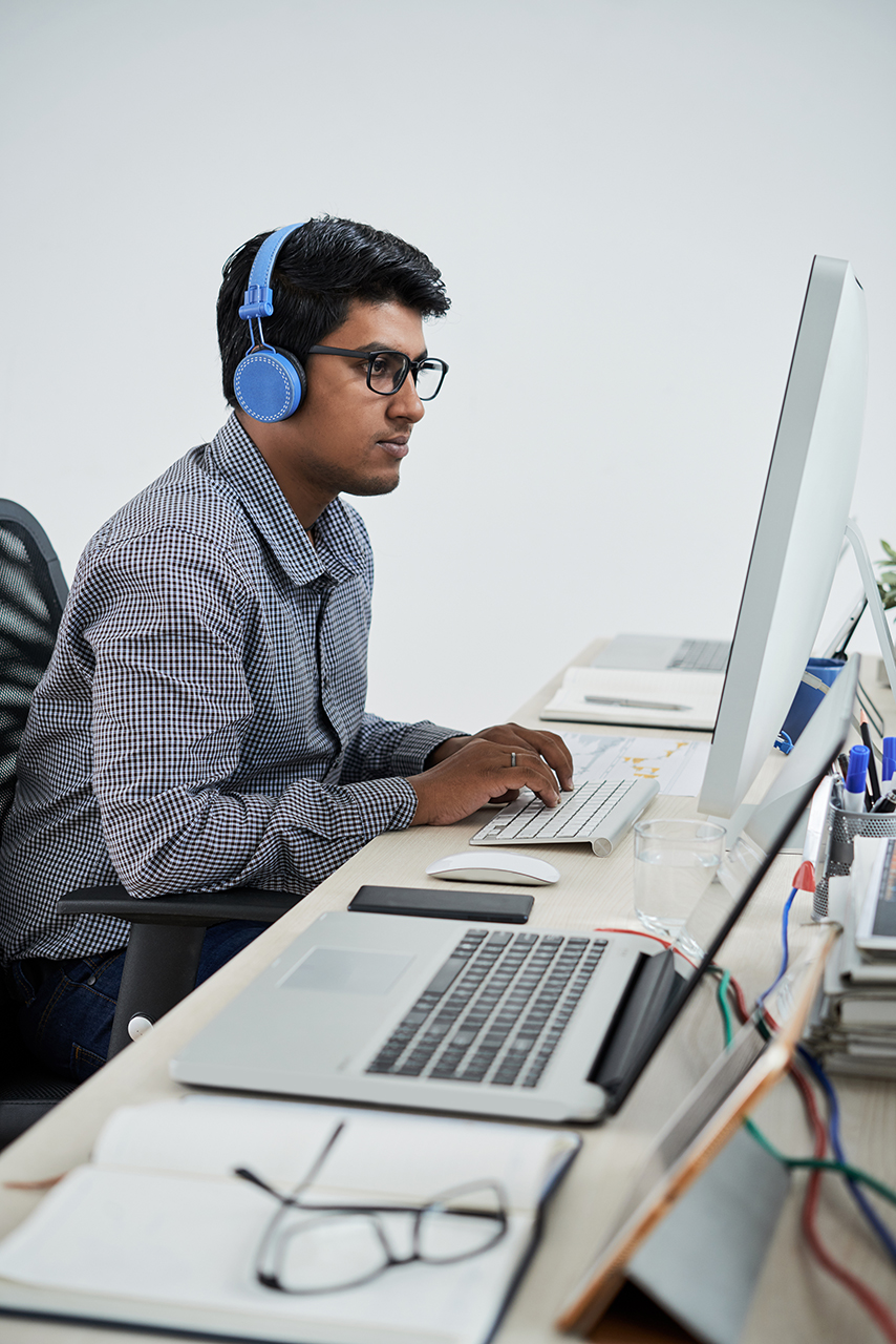Indian programmer listening to music when working in office